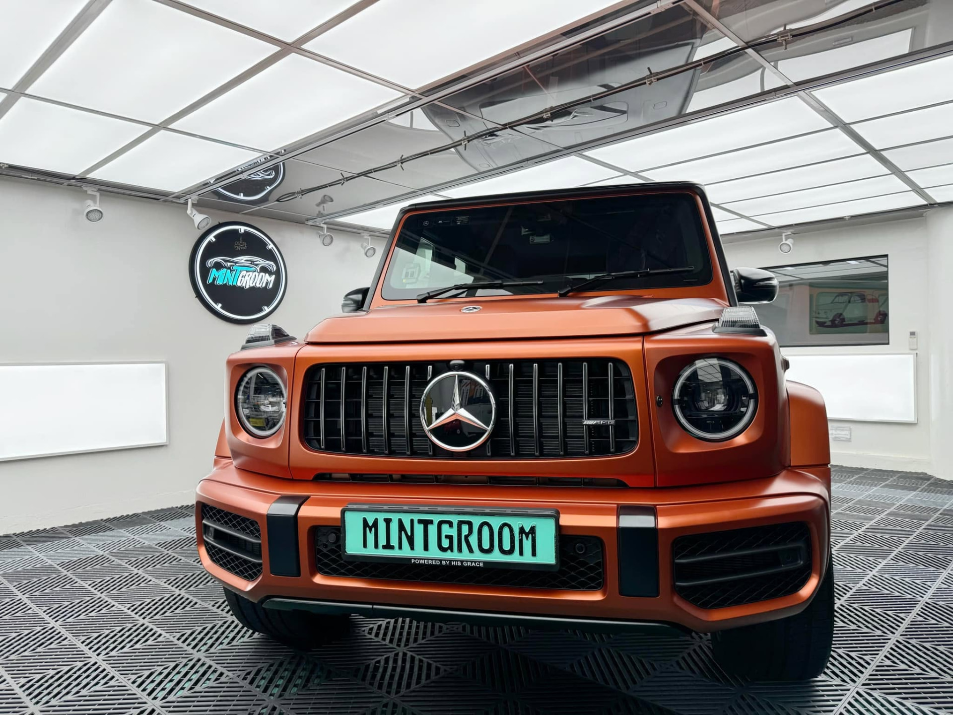 Orange Mercedes-AMG G 63 with a mint MintGroom plate in the MintGroom studio